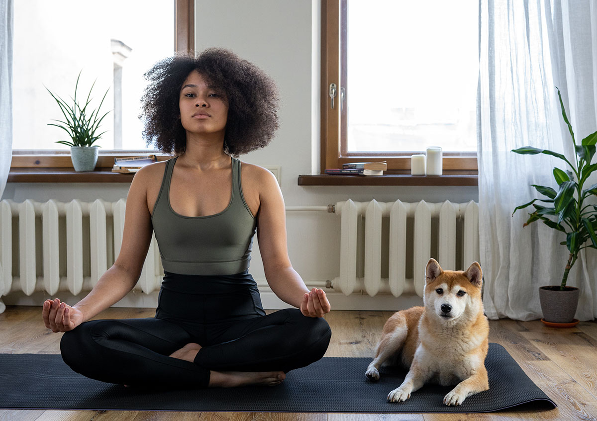 Woman practicing yoga with her dog